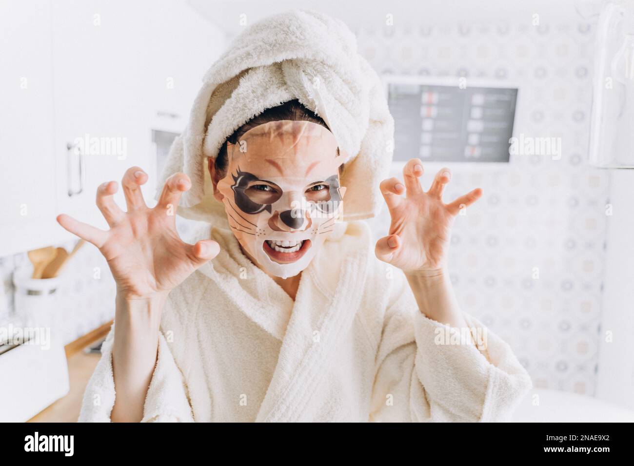 Donna che si ingoola intorno in una maschera per la pelle sotto forma di una tigre Foto Stock