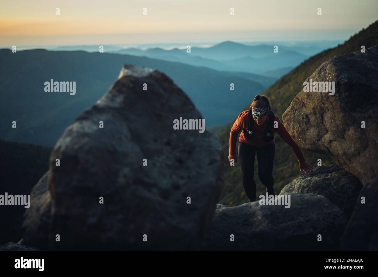 Donna escursioni tra massi all'alba in montagne bianche Foto Stock