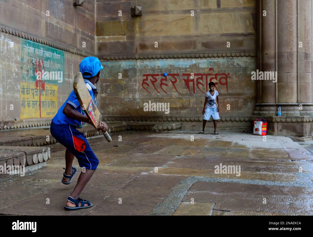 Bambini che giocano a cricket sui ghat; Varanasi, India Foto Stock