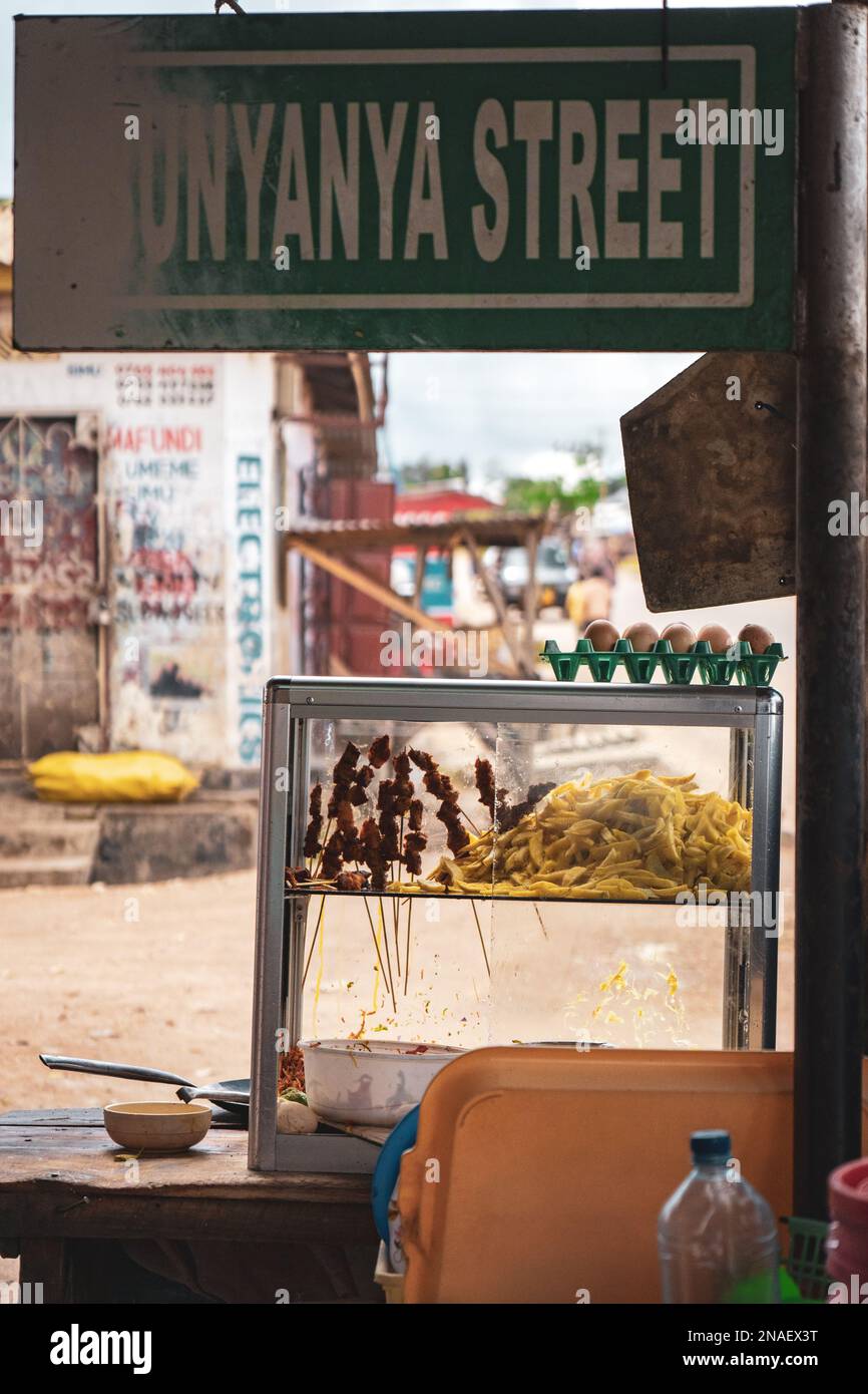 Locale africano fast food stand. I cartelli stradali sono usurati. Patatine fritte, uova, insalata e carne conservati in una scatola di vetro. Foto Stock