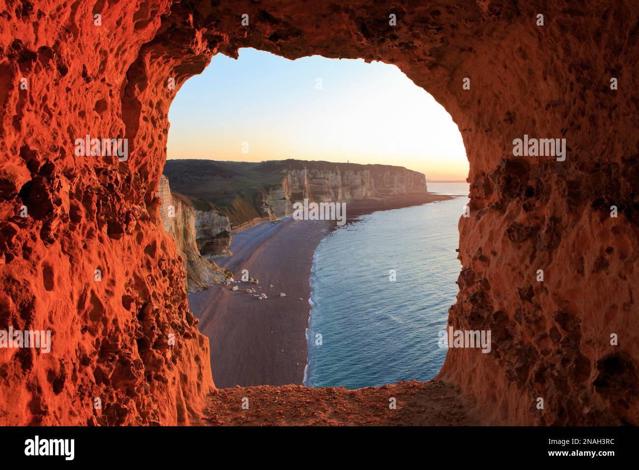Una finestra con una vista panoramica attraverso le scogliere di gesso di Etretat (Senna Marittima) in Normandia, Francia al tramonto Foto Stock
