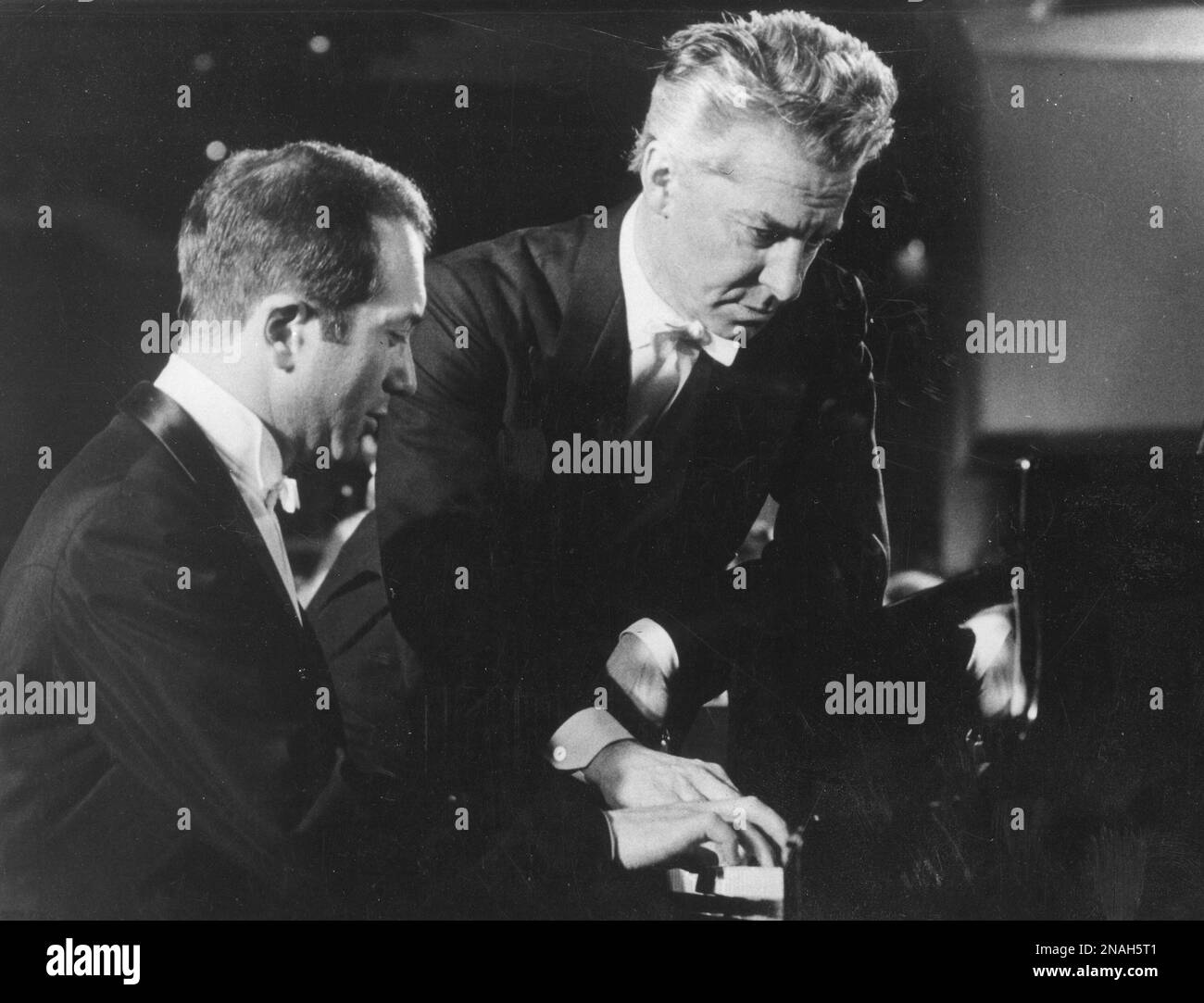 FILE This is a 1976 file photo of pianist Alexis Weissenberg. left, and Austrian conductor Herbert von Karajan , as they go over a part at the grand piano in West Berlin. Bulgarian-born pianist Alexis Weissenberg, whose love of music from the age of 3 saved him and his mother in a concentration camp and carried him to the heights of 20th century performances with Herbert von Karajan and Leonard Bernstein, has died. He was 82. Bulgaria's Ministry of Culture confirmed Monday Jan. 9, 2012 the death of Weissenberg, who was born in the capital Sofia but spent most of his life abroad and became a Fr Foto Stock