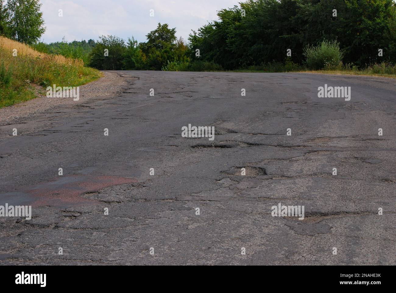 Buco nella strada. Asfalto rotto. Superficie distrutta. Strada incrinata. Foto Stock