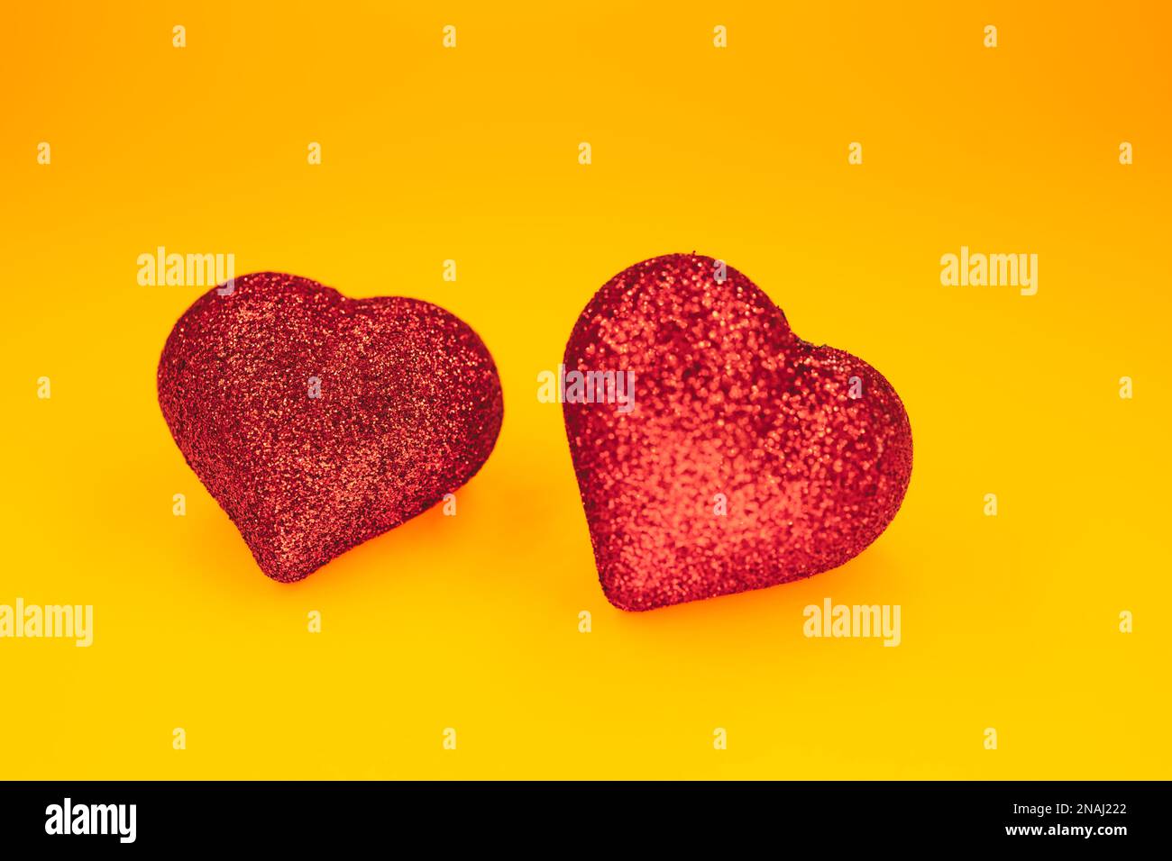 due cuori si formano sullo sfondo giallo Foto Stock