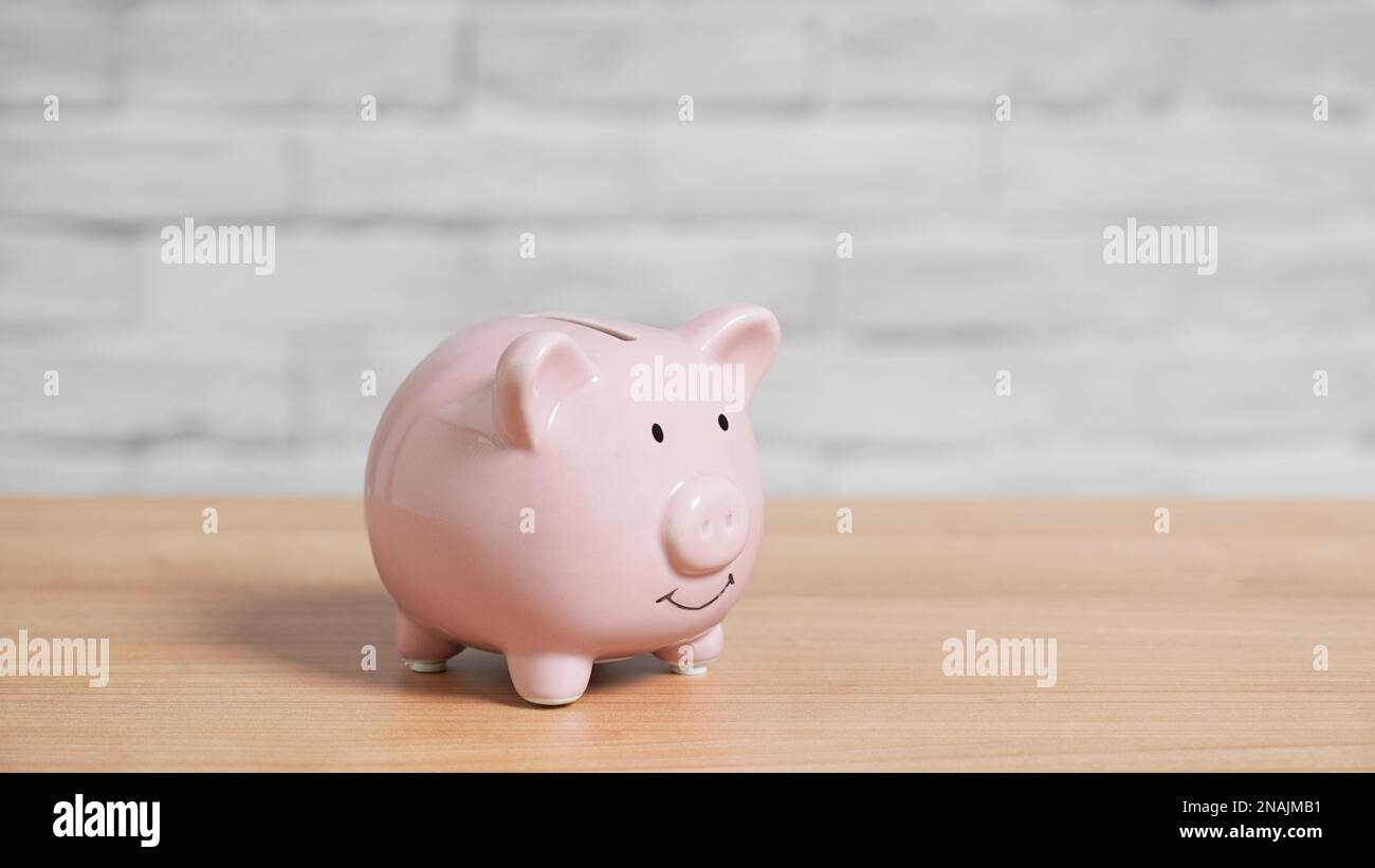 Banco di porcellini o banca di piggybank su tavolo con spazio di copia Foto Stock