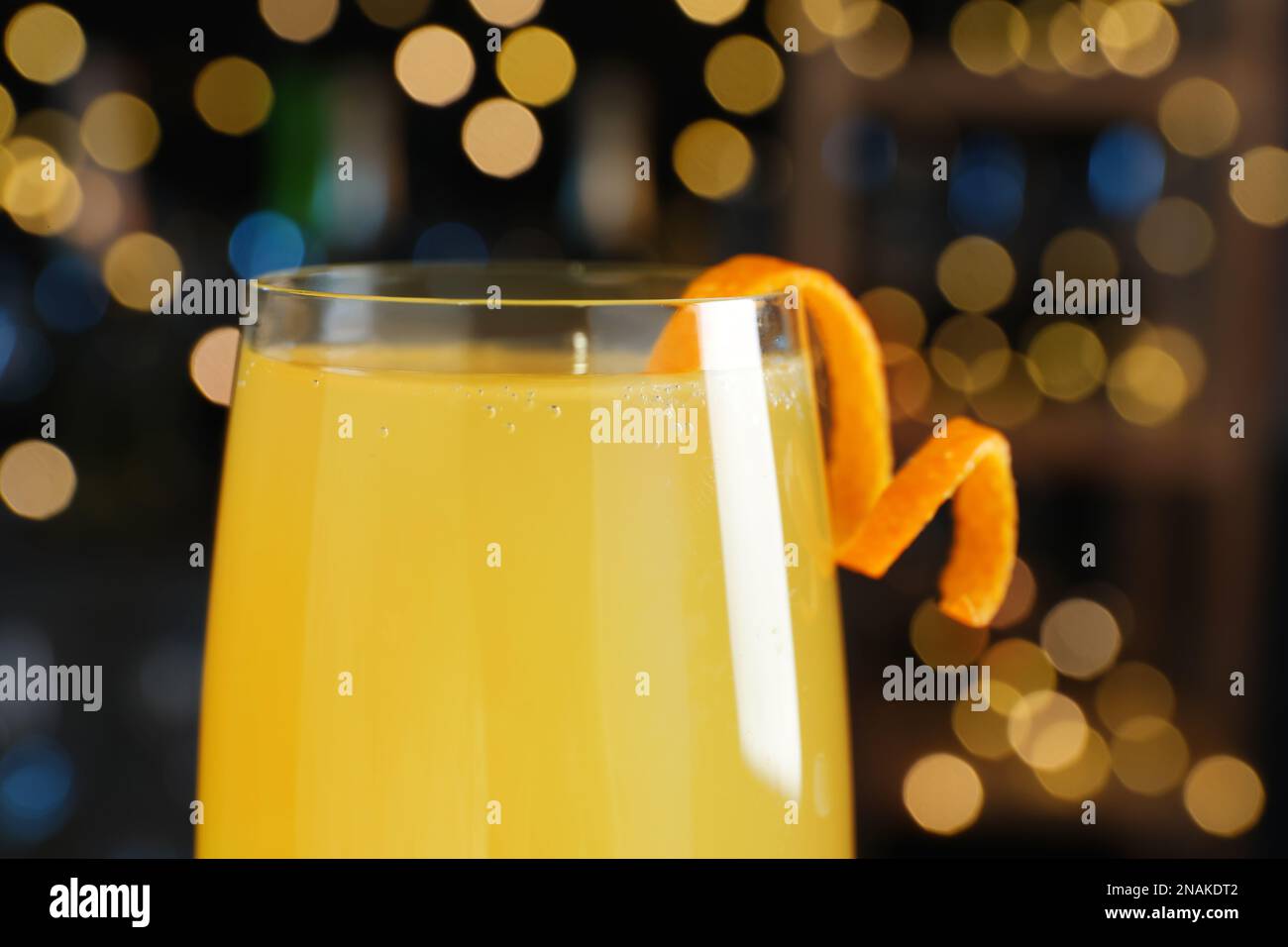 Cocktail Mimosa con decorazione contro le luci sfocate, primo piano Foto Stock