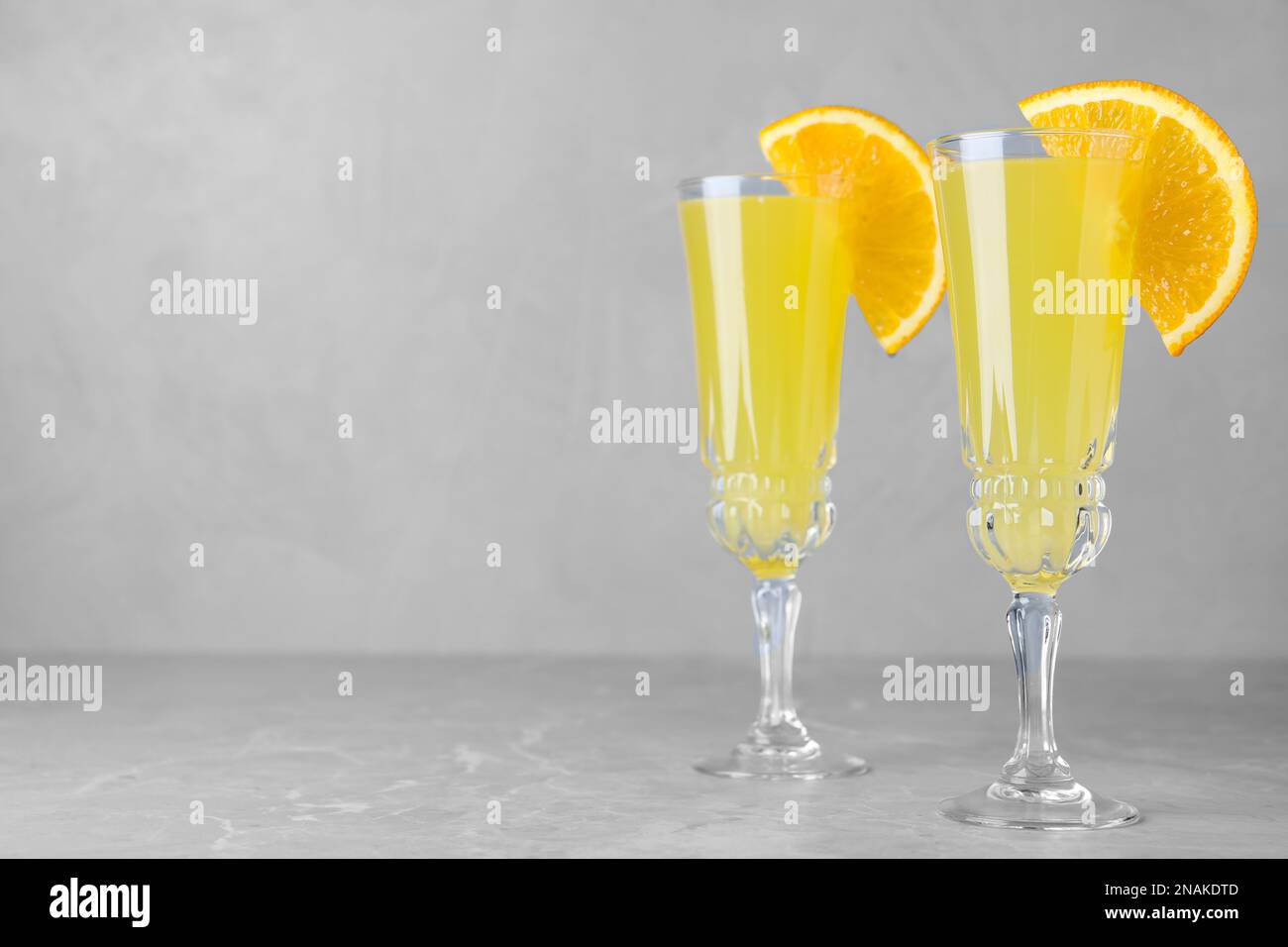 Bicchieri di cocktail Mimosa con decorazione su tavolo in marmo. Spazio per il testo Foto Stock