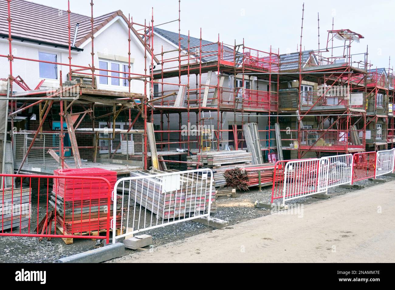 Case moderne in costruzione con ponteggi e barriere di accesso, Troon, Scozia, Regno Unito Foto Stock