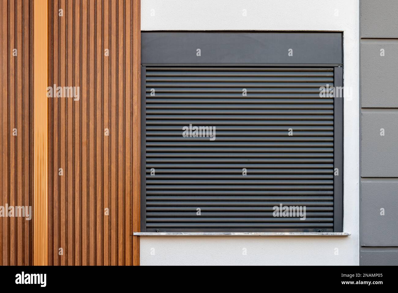L'edificio la cui facciata è ricoperta da pannelli in PVC con motivi in legno e la cui finestra è fatta di persiane Foto Stock