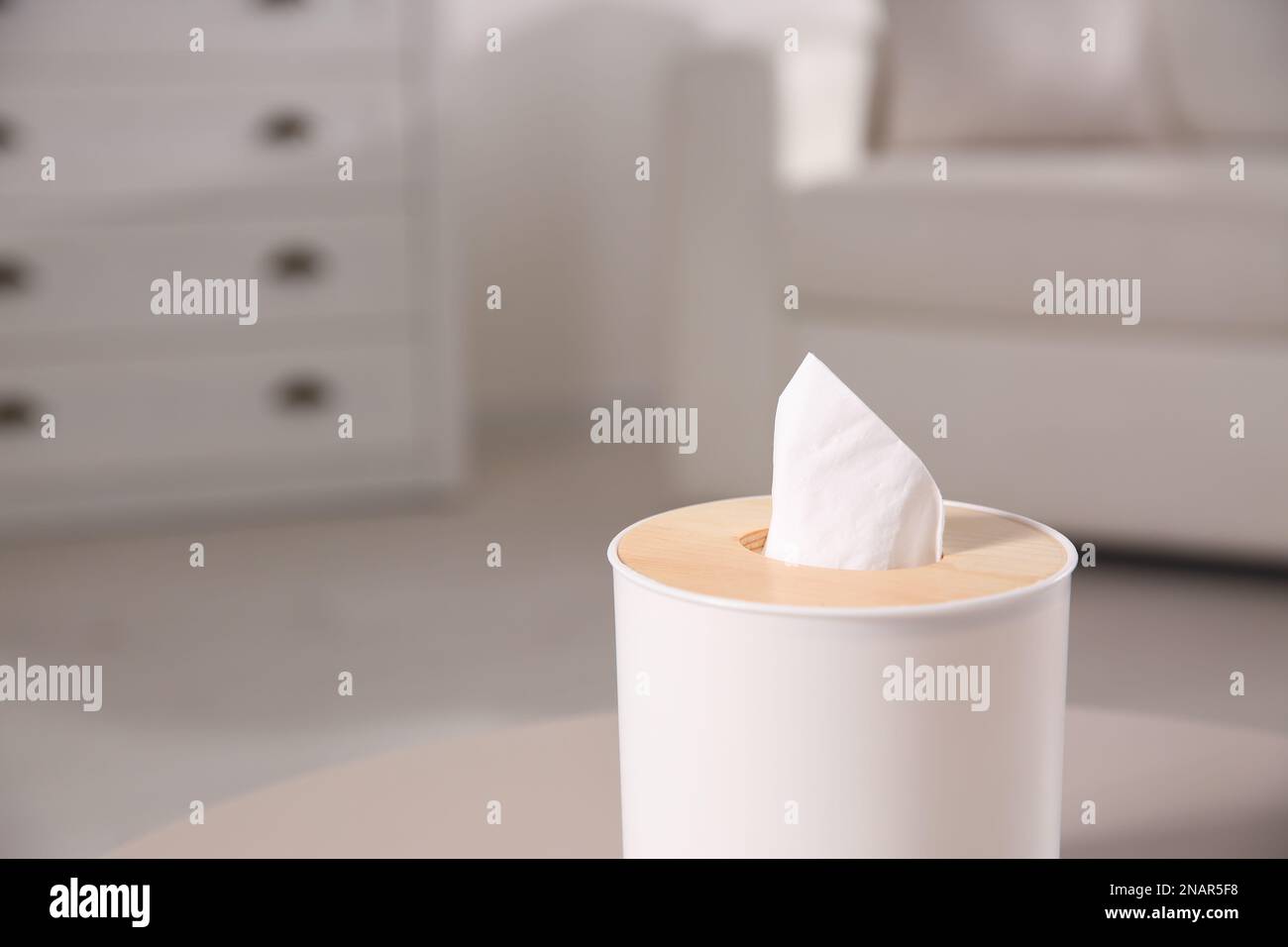 Scatola con fazzolettini di carta su un tavolo luminoso in soggiorno, primo piano. Spazio per il testo Foto Stock