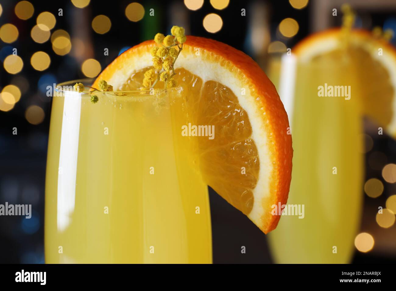 Cocktail Mimosa con decorazione contro le luci sfocate, primo piano Foto Stock