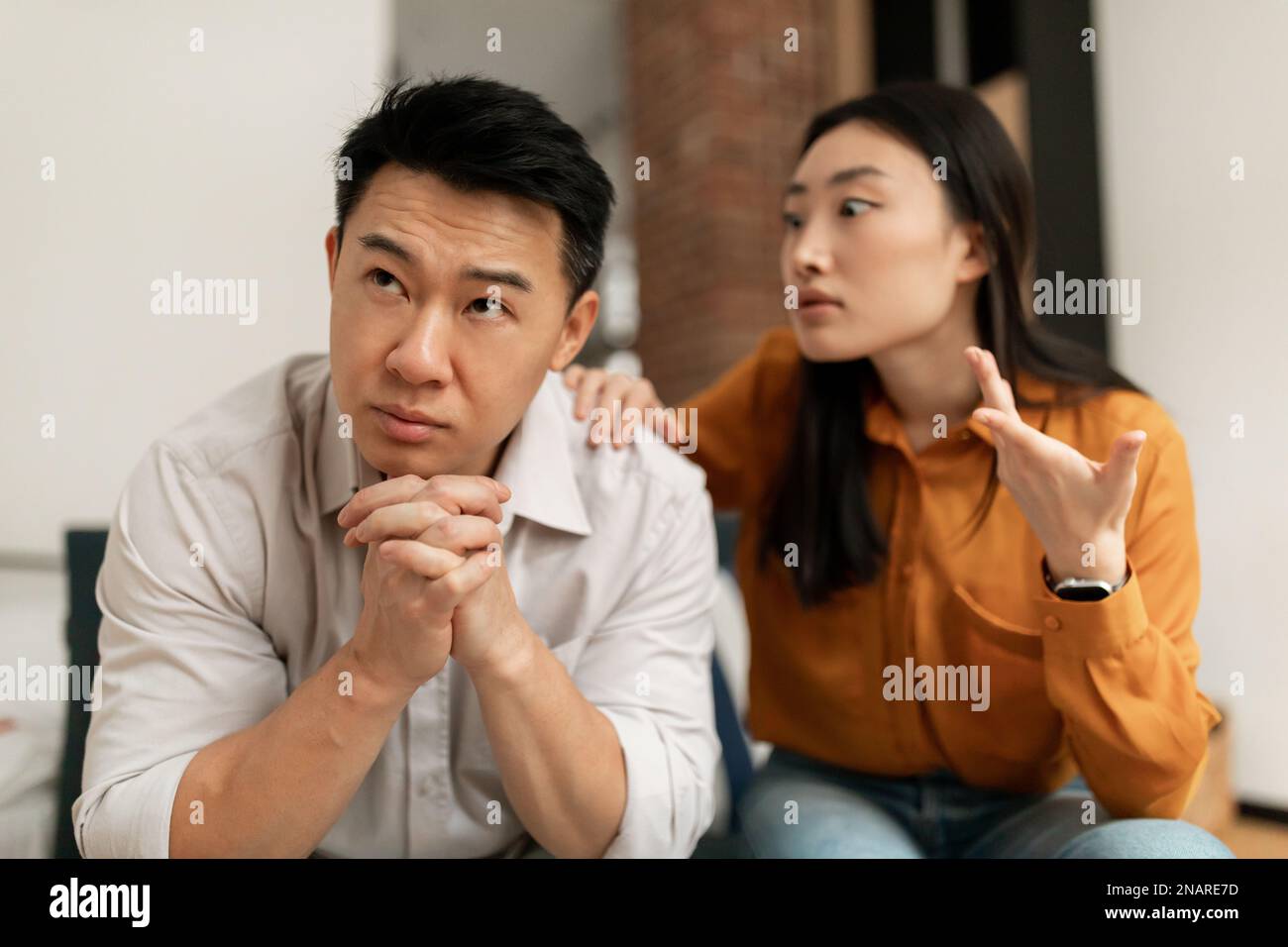 Emotiva moglie cinese urlare e gesturing al marito di mezza età, avendo difficoltà nel matrimonio Foto Stock