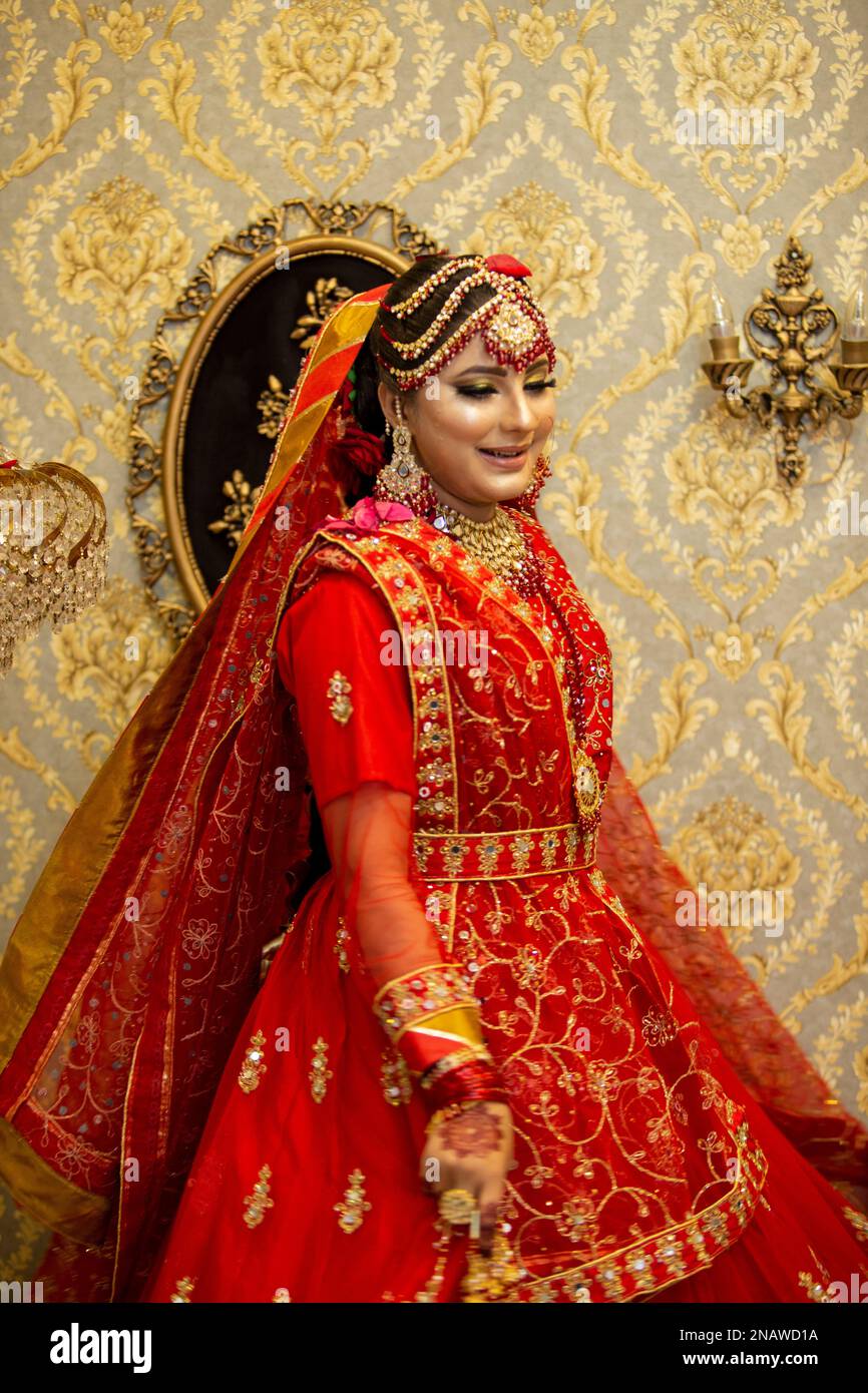 Sposa indiana e pakistana vestita con abiti da sposa tradizionali Foto Stock