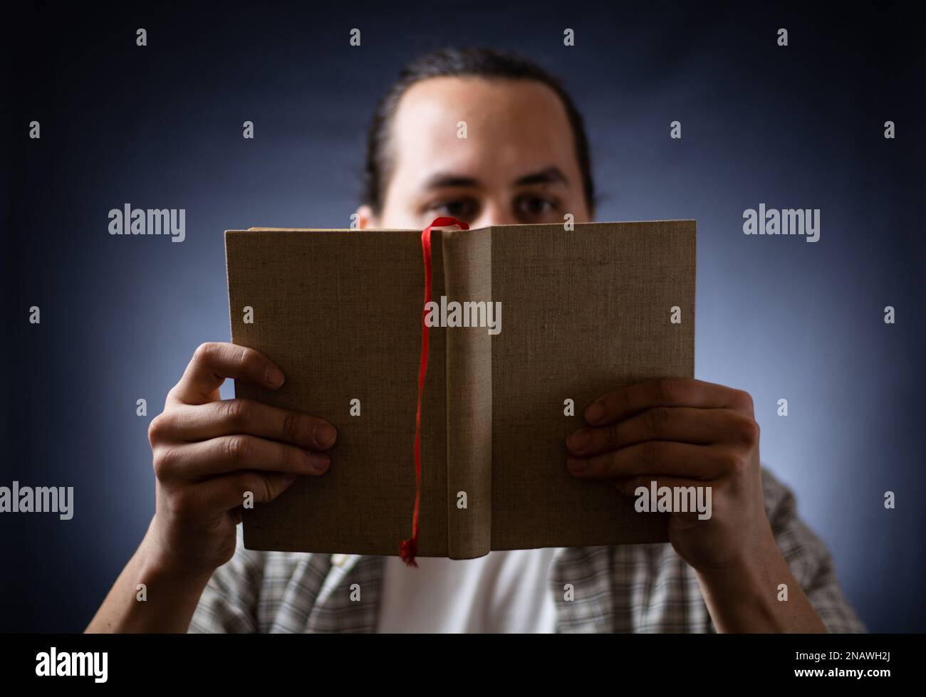 L'uomo caucasico legge un libro di notte Foto Stock