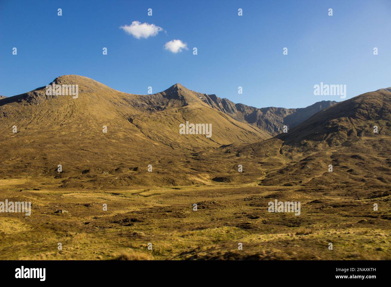 Vista sulle montagne ricoperte di erica di Glen Shiel nelle Highlands scozzesi con la Sella sullo sfondo Foto Stock