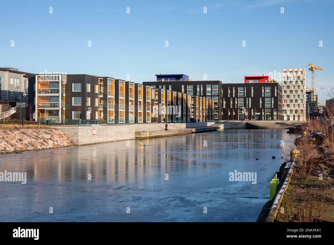 Edifici residenziali di Saukonpaasi situati nel vecchio bacino portuale congelato nel distretto di Jätkäsaari o Länsisatama di Helsinki, Finlandia Foto Stock