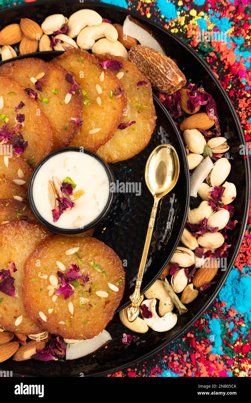 I Malpua o Pua sono tradizionali pancake di Mithai dolci Indiani ubriachi, affumicati, imbevuti o ricoperti di sciroppo di zucchero Cheeni Ki Chasni e Pistacchio Foto Stock