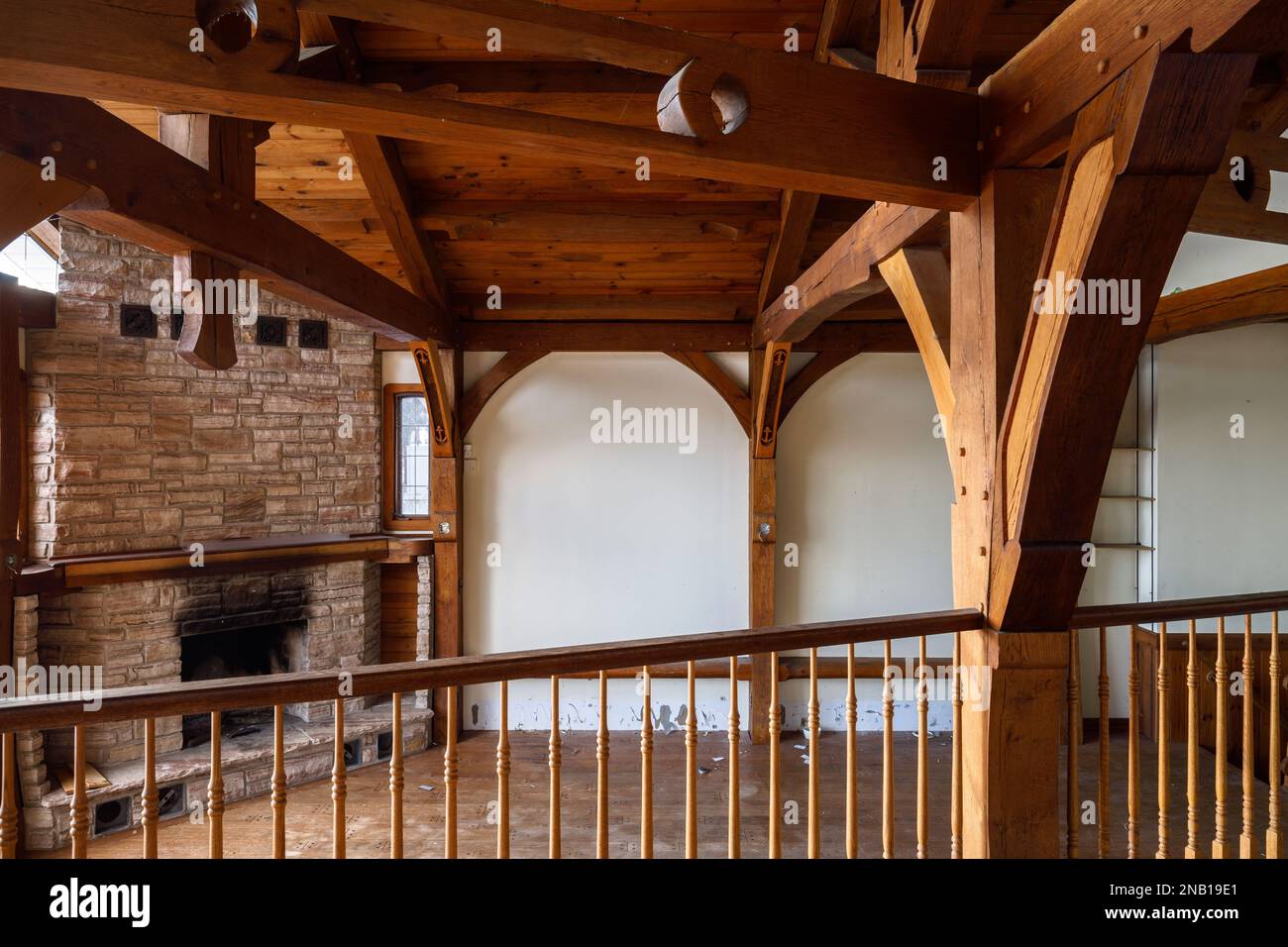 Un ampio soggiorno in legno e rustico con camino all'interno di una casa abbandonata. Questa casa è stata da allora demolita. Foto Stock