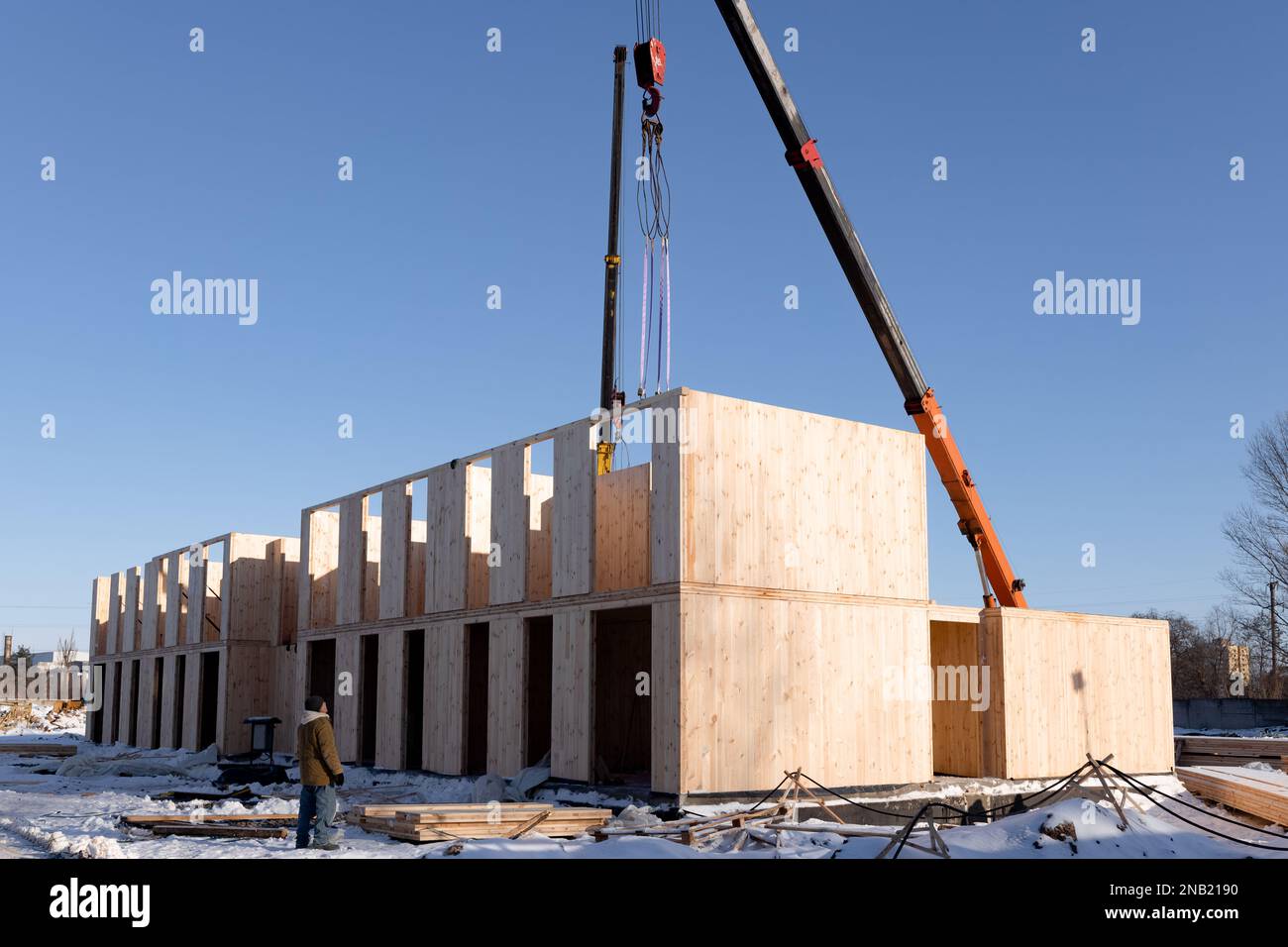 Il processo di costruzione di una nuova e moderna casa modulare realizzata con pannelli di sorso in composito in una giornata invernale di sole. Foto Stock