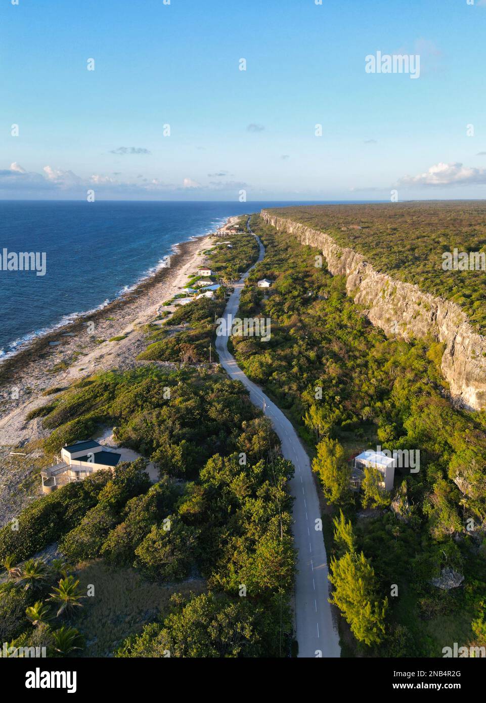 Una splendida vista aerea delle Isole Cayman Cayman Brac, che mostra il magnifico Bluff, strada tortuosa, alberi lussureggianti e mare dei Caraibi cristallino Foto Stock