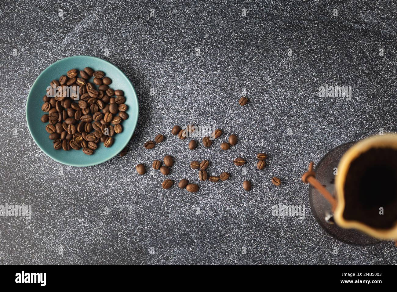 Preparazione del caffè versato in un contenitore di vetro sul piano di appoggio in pietra pulita con fondo in marmo bianco Foto Stock