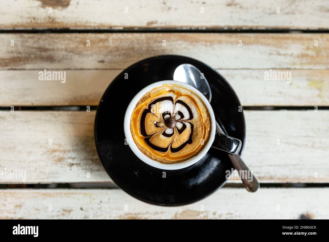 Primo piano di un disegno floreale sulla schiuma del cappuccino Foto Stock