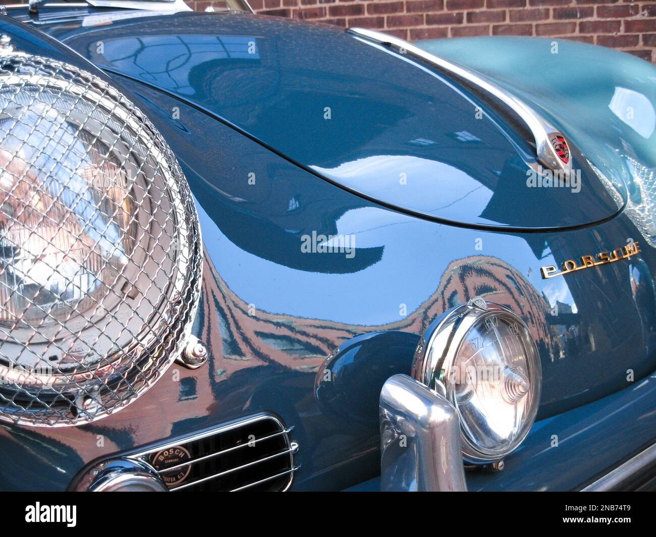Uno schermo metallico fissato ai fari anteriori di una Porsche 356 Speedster 1957 vintage per la protezione da trucioli di pietra e altri pericoli stradali Foto Stock