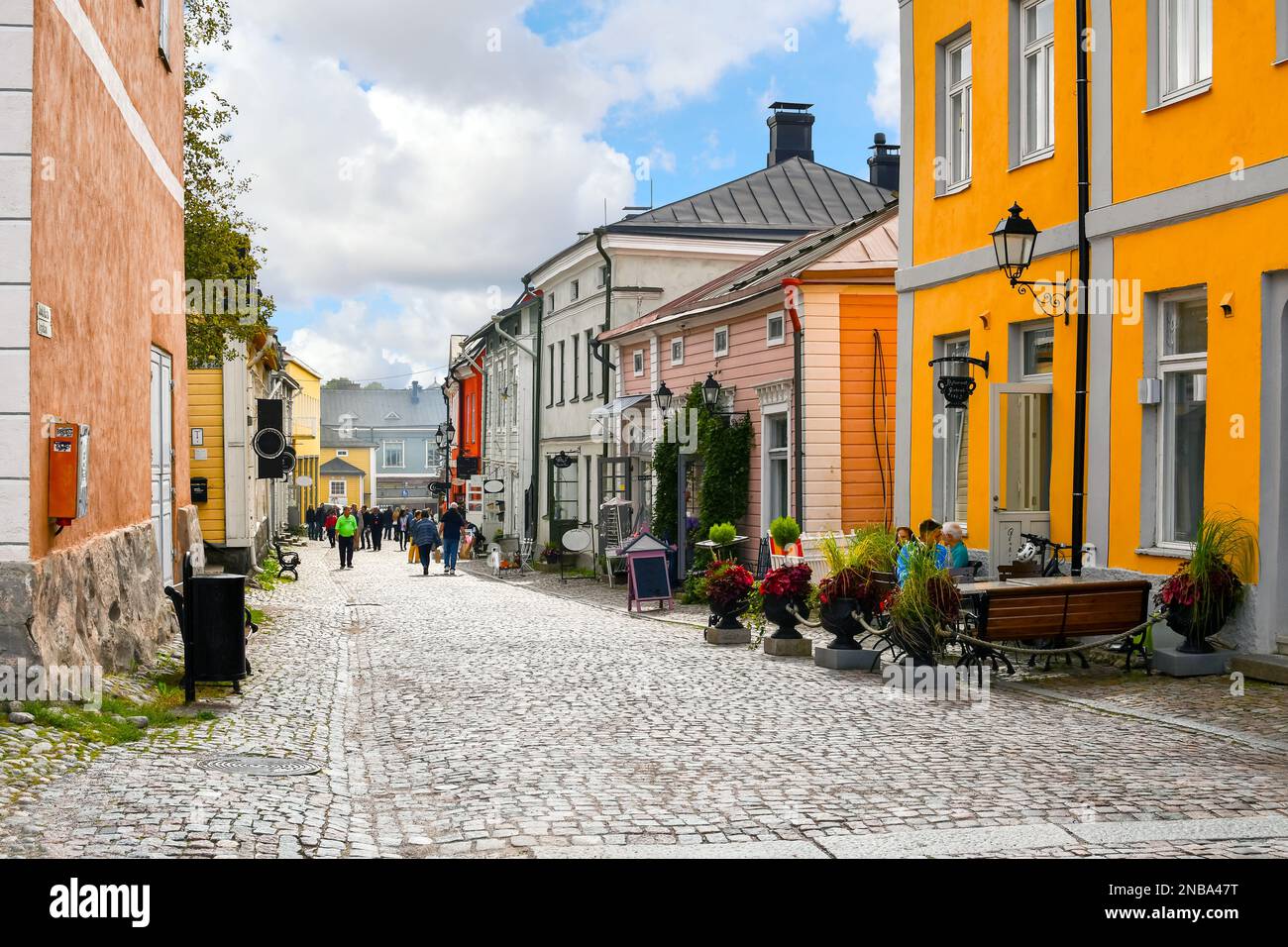 Negozi colorati e pittoreschi, caffetterie ed edifici in legno fiancheggiano la principale strada acciottolata attraverso il centro storico medievale di Porvoo, Finlandia. Foto Stock