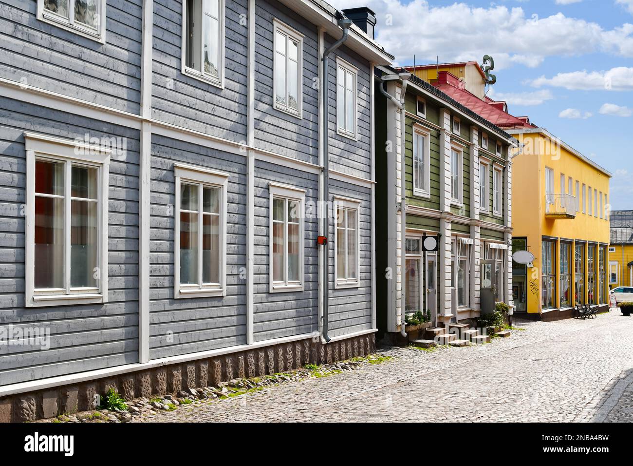 Negozi colorati e pittoreschi ed edifici in legno fiancheggiano la principale strada acciottolata attraverso il centro storico medievale di Porvoo, Finlandia Foto Stock