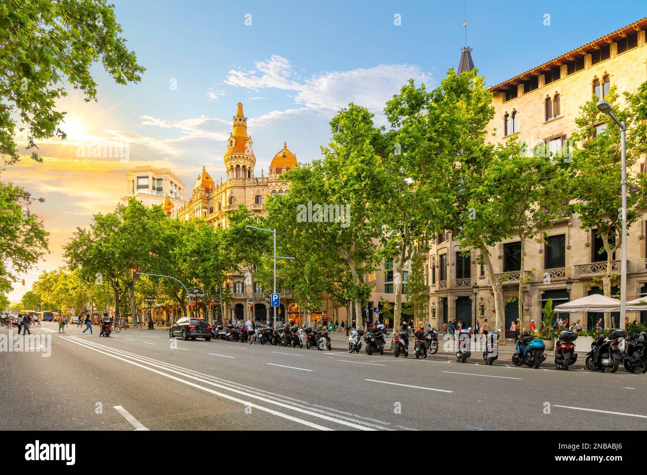 Il sole tramonta sull'edificio Cases Antoni Rocamora e sul viale Paseo de Gracia di fronte a Plaza de Catalunya nel quartiere Eixample, Barcellona Spagna Foto Stock