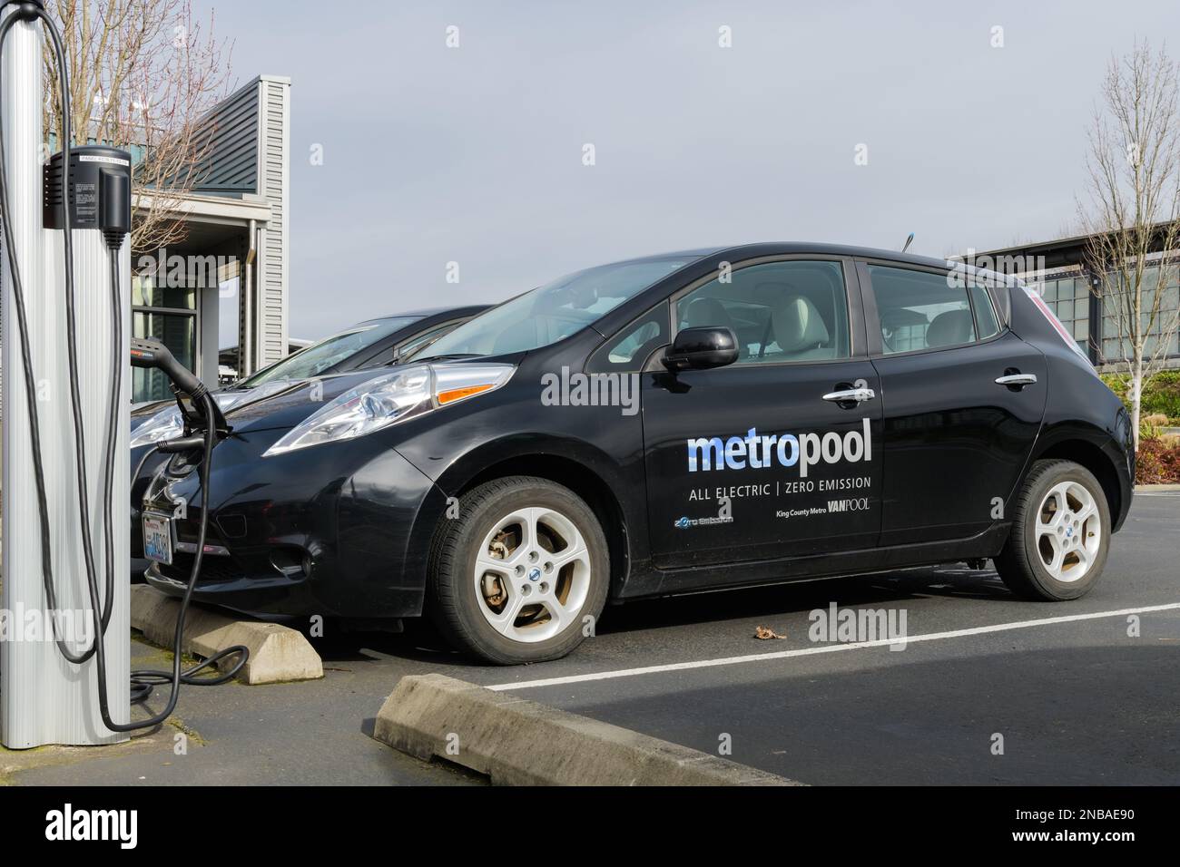 Tukwila, WA, Stati Uniti d'America - 12 febbraio 2023; vista laterale della ricarica di veicoli elettrici a emissioni zero della contea di Nissan Leaf King MetroPool Foto Stock
