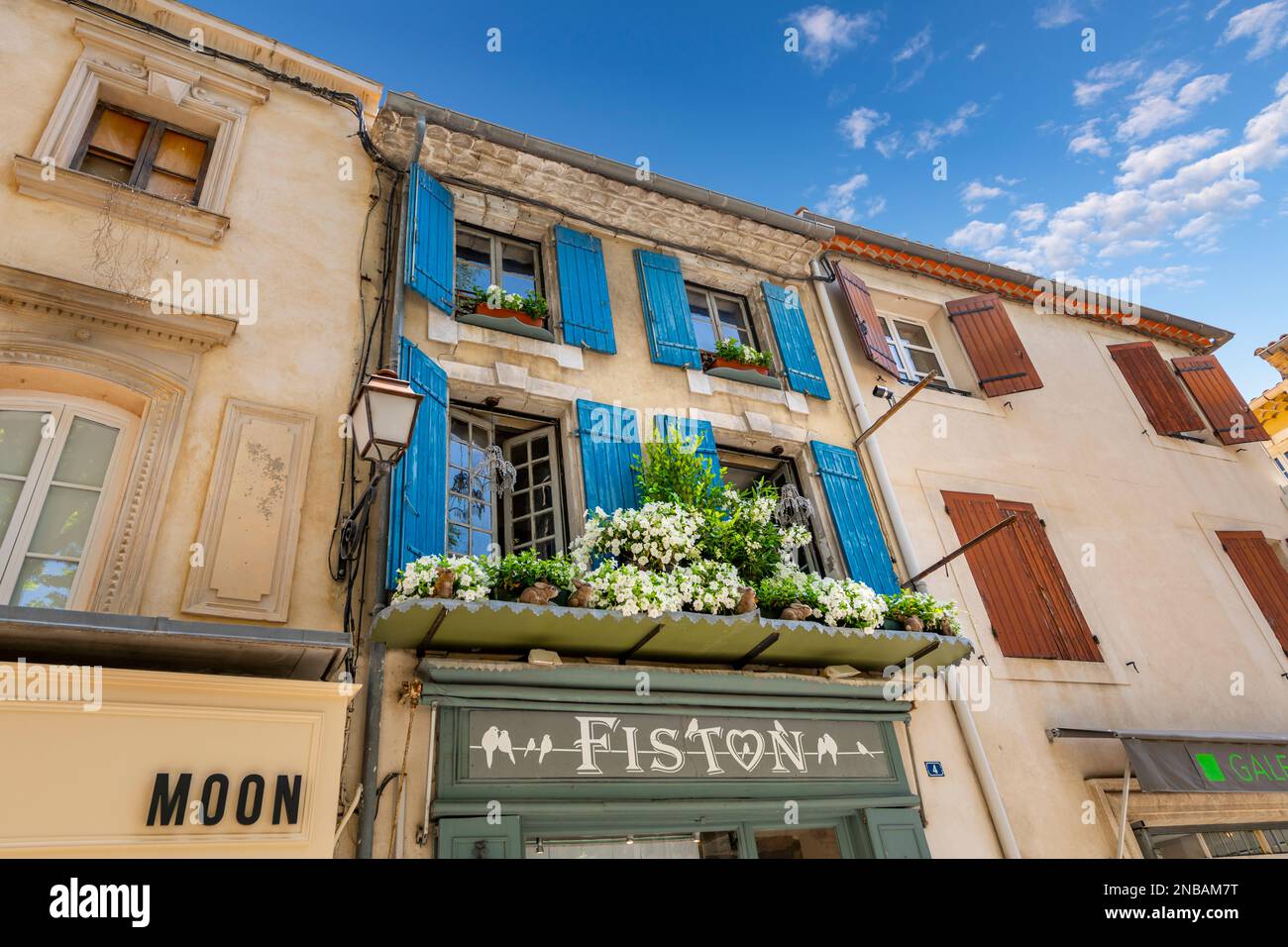 Una pittoresca finestra piena di fiori su una facciata boutique e negozio di articoli da regalo e l'ingresso nello storico villaggio francese di Saint-Remy-de-Provence, Francia . Foto Stock