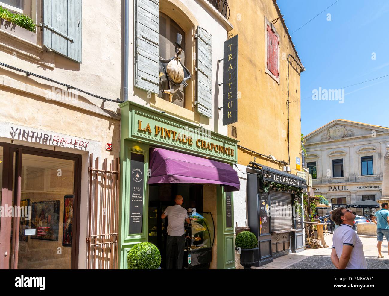 Una delle molte strade e vicoli tipici di colorati caffè e negozi lungo il marciapiede nella storica città di Saint-Remy-de-Provence in una giornata di sole estate. Foto Stock
