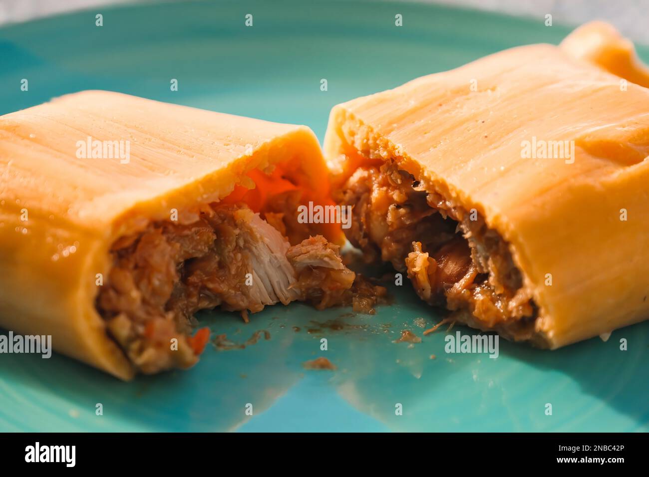 Hallaca o Tamale primo piano su un tavolo rustico e un piatto blu, messicano e venezuelano cibo tradizionale Foto Stock