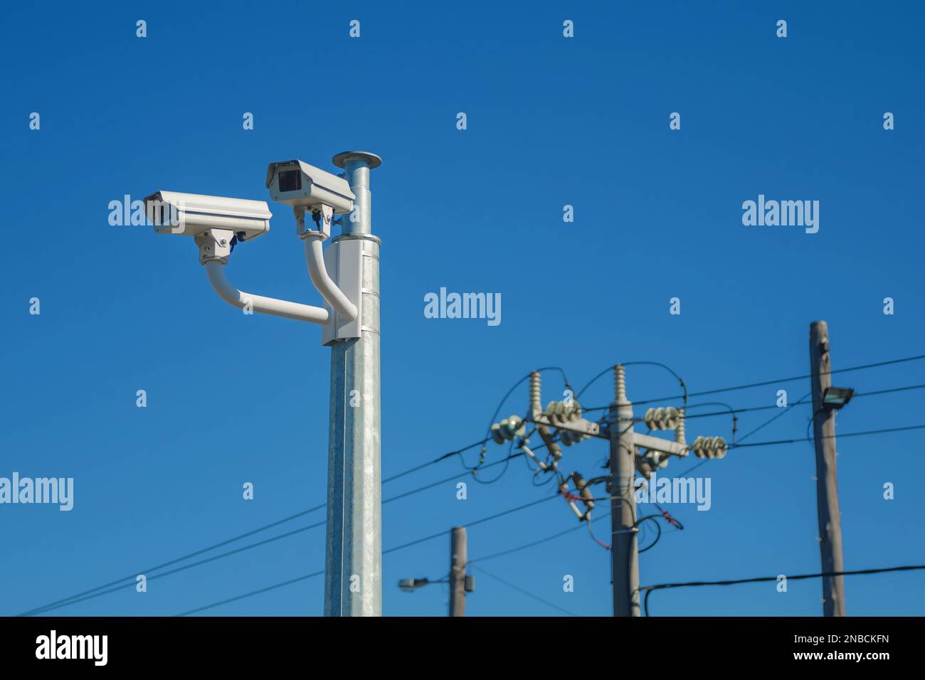 Telecamere di sorveglianza a circuito chiuso e linee elettriche Foto Stock