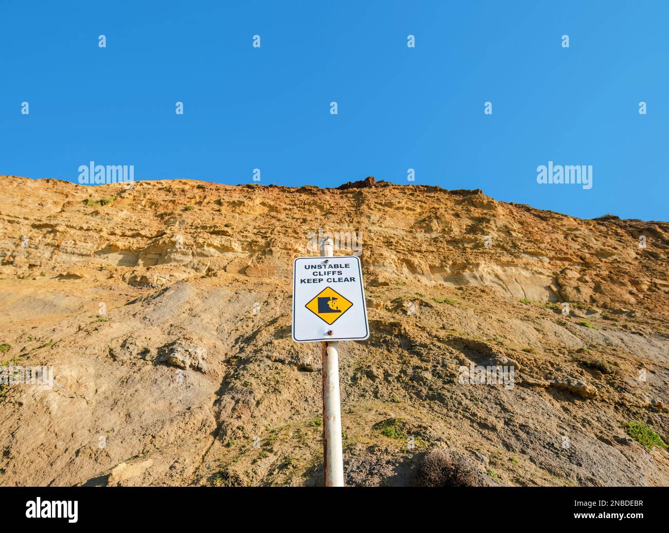 Cartello che consiglia di tenere lontano da pericolose scogliere a Jan Juc Beach, Surf Coast Shire, Great Ocean Road, Victoria, Australia Foto Stock