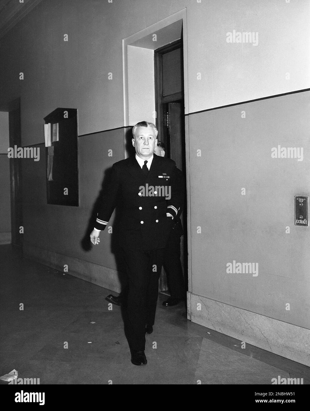 Lt. Adam Rother, 41-year-old Coast Guardsman, walks down the corridor of the Richmond County courthouse in the Staten Island borough of New York City, March 6, 1944, where his trial began on charges that he slew Rita Costello of Staten Island, his 28-year-old sweetheart. Rother said his service revolver went off accidentally during a scuffle in a cab. His wife, Harriet, will testify in his defense. (AP Photo/Matty Zimmerman) Foto Stock