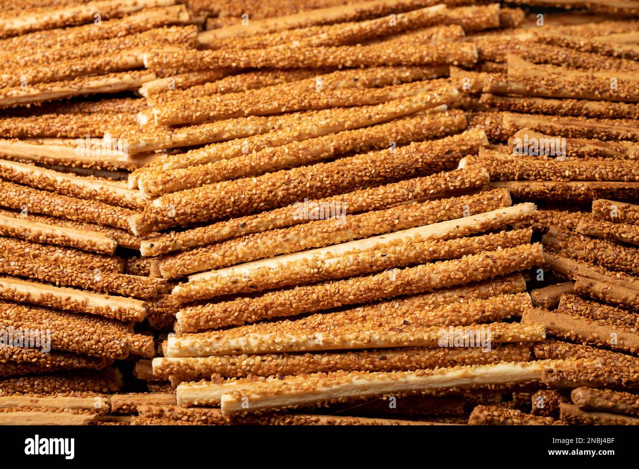 Il pane di pretzel si stacca con i semi di sesamo. Pretzel deliziosi in massa. primo piano Foto Stock