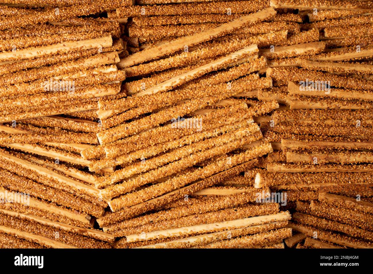 Il pane di pretzel si stacca con i semi di sesamo. Pretzel deliziosi in massa. primo piano Foto Stock