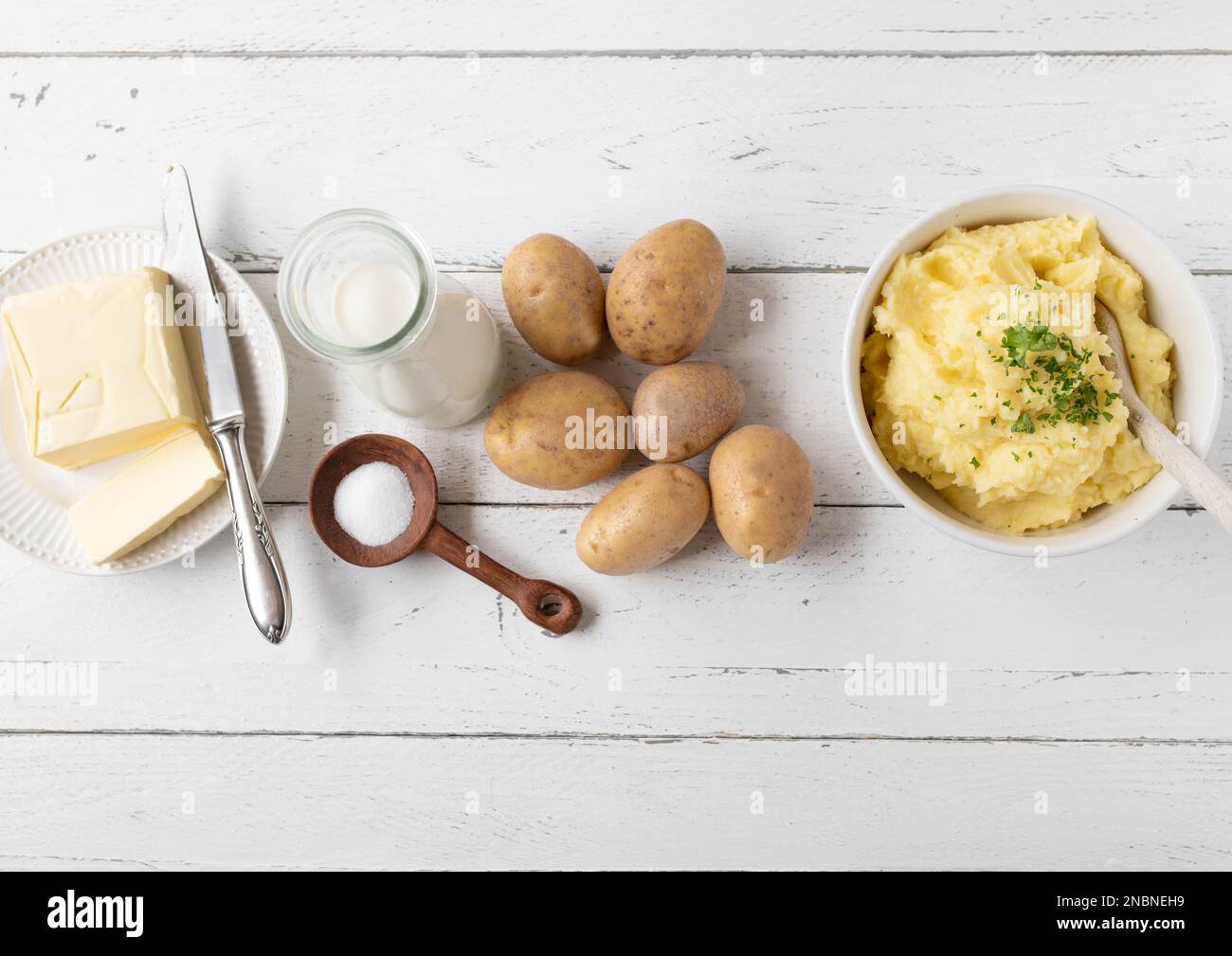 Ingredienti per cucinare o preparare purè di patate su sfondo bianco con spazio per il testo. Giacitura piatta Foto Stock