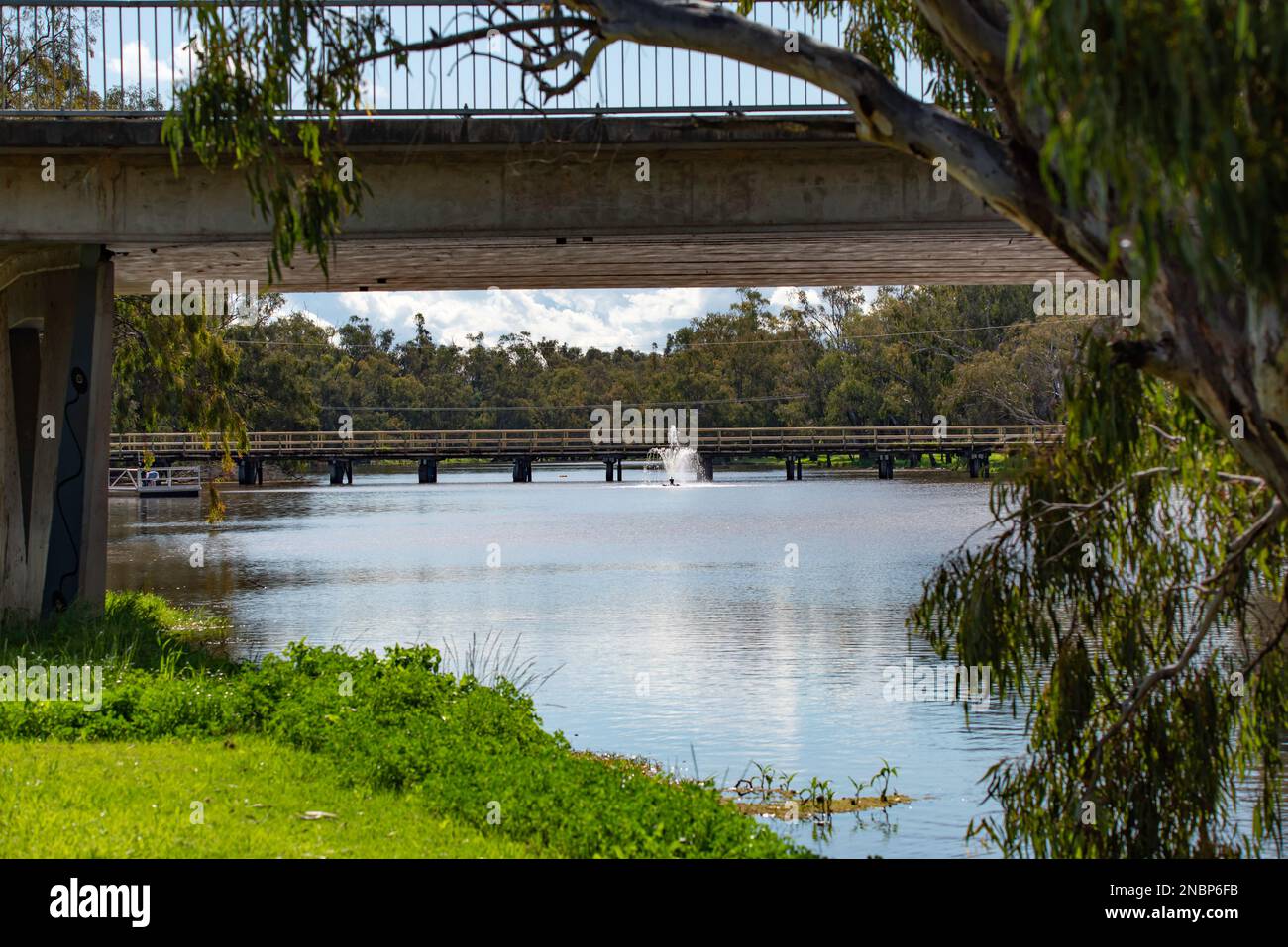 Guardando sotto l'Oxley Bridge, passate una delle fontane del Lago Forbes fino al Lachlan Street Bridge a Forbes, nel nuovo Galles del Sud, Australia Foto Stock