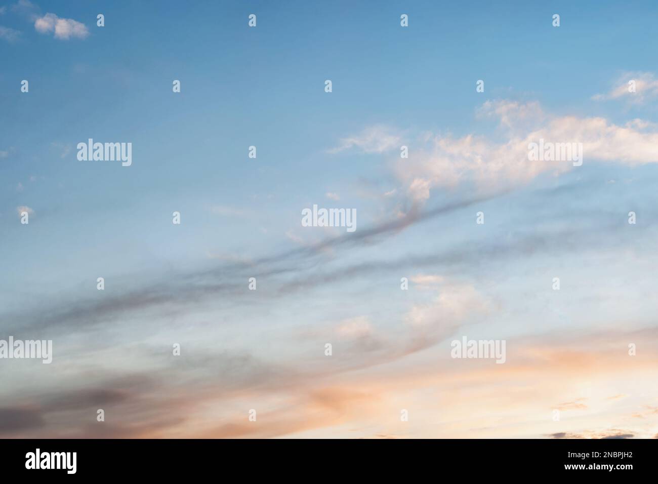 Cielo al tramonto con un gradiente di colore da caldo a freddo. Cielo di fondo con nuvole distese di luce al sole. Foto Stock