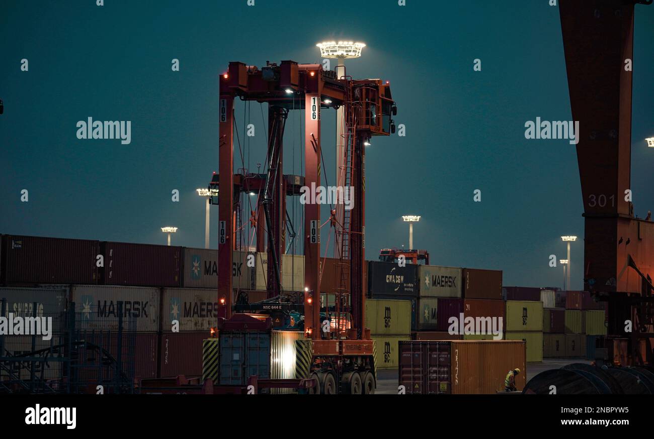 Europa Germania Amburgo di notte - Container Transporter al lavoro, porto di Amburgo in Germania Foto Stock
