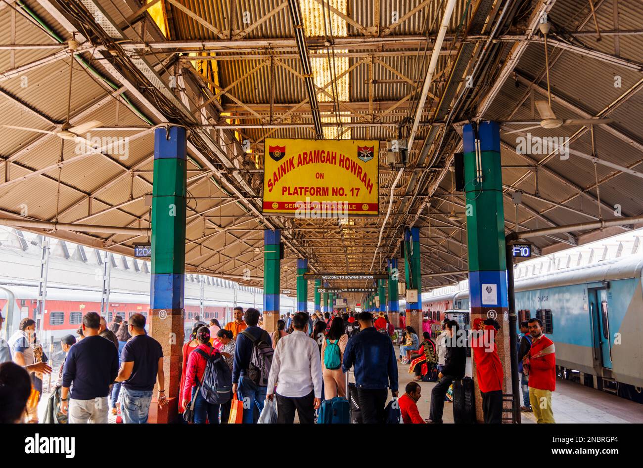 Cartello con il nome su piattaforma alla stazione ferroviaria di Howrah Junction, Howrah, Kolkata, West Bengala, India (cartello giallo con testo rosso, "servizio con un sorriso") Foto Stock