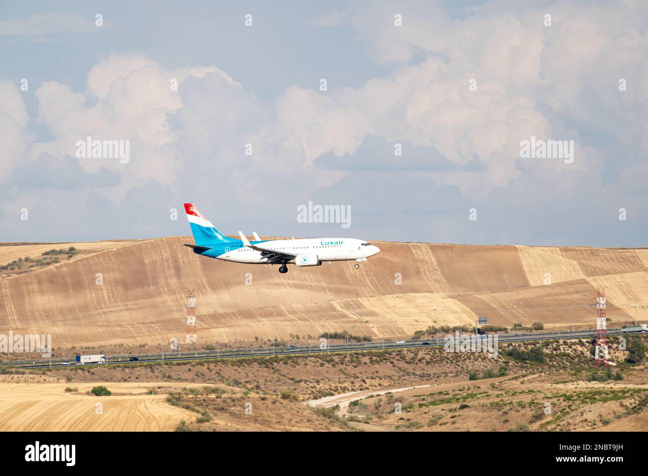 Aereo di linea Luxair bianco, blu e rosso, con il carrello abbassato, in avvicinamento all'aeroporto Barajas di Madrid. Foto Stock