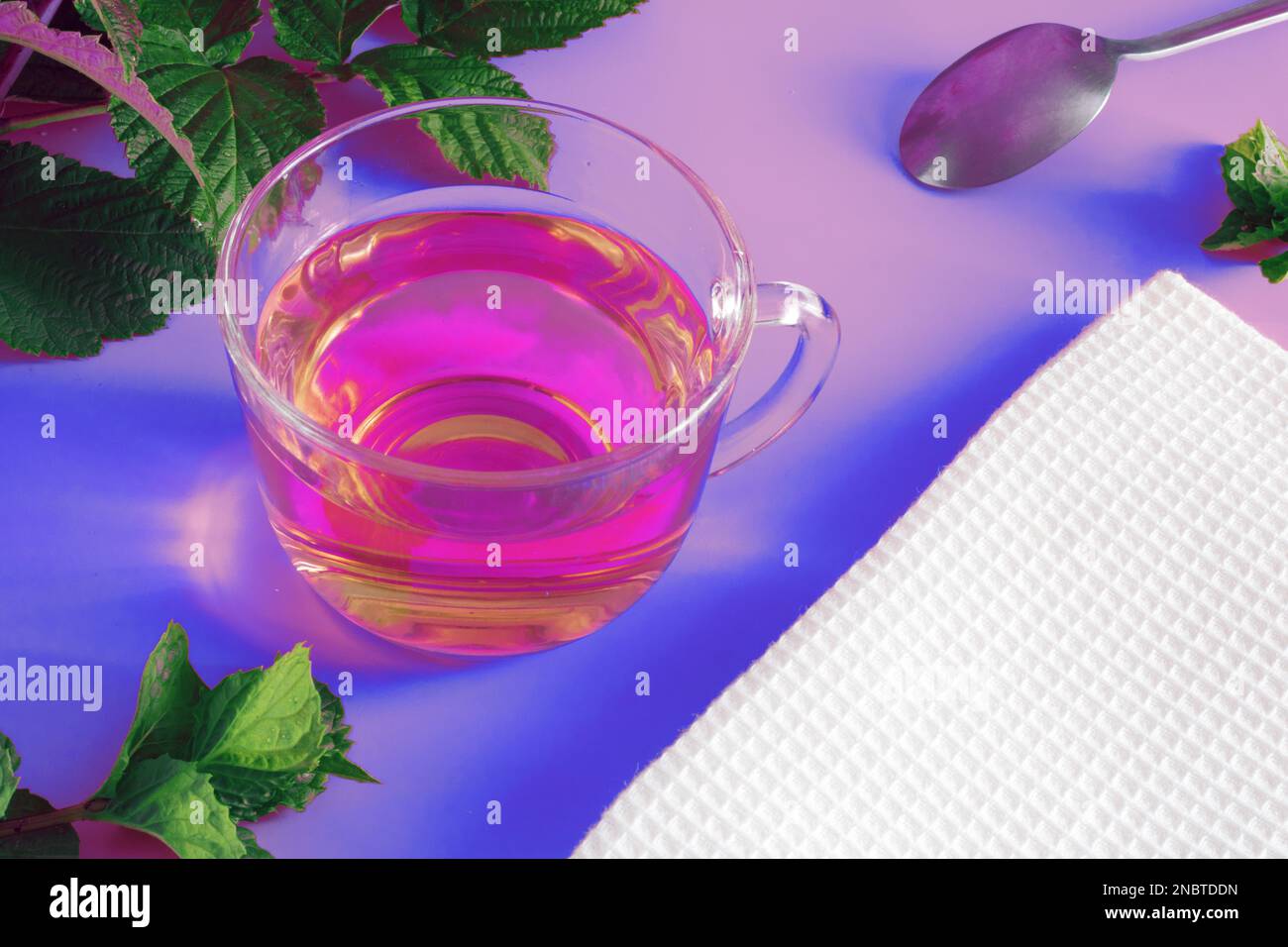 Bicchiere di tè aromatico caldo su sfondo rosa, neon, bevanda Foto Stock