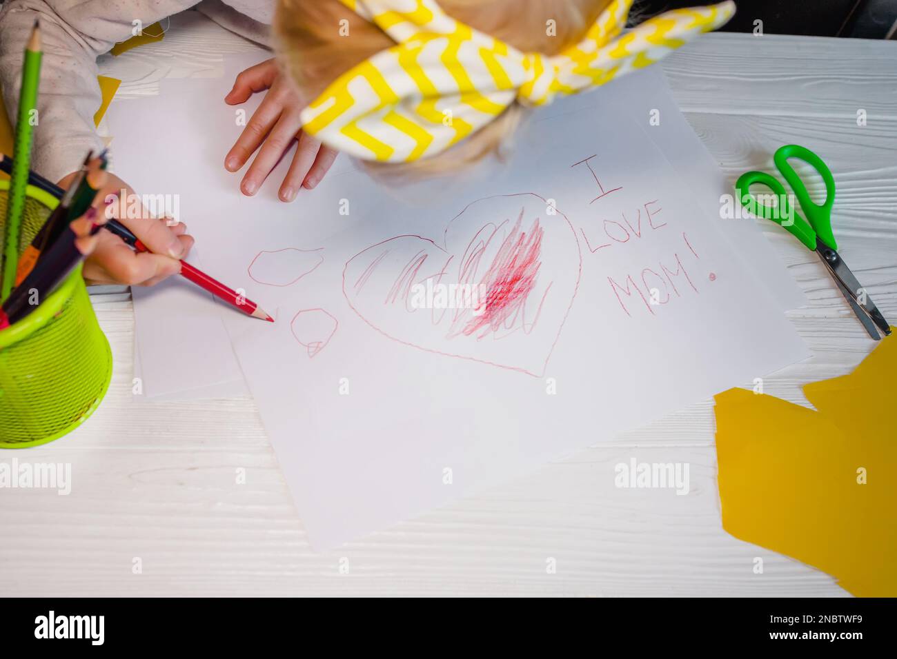 Amo la mamma il bambino ha scritto le congratulazioni per la giornata della madre. Cuore e iscrizione su una cartolina per la mamma Foto Stock