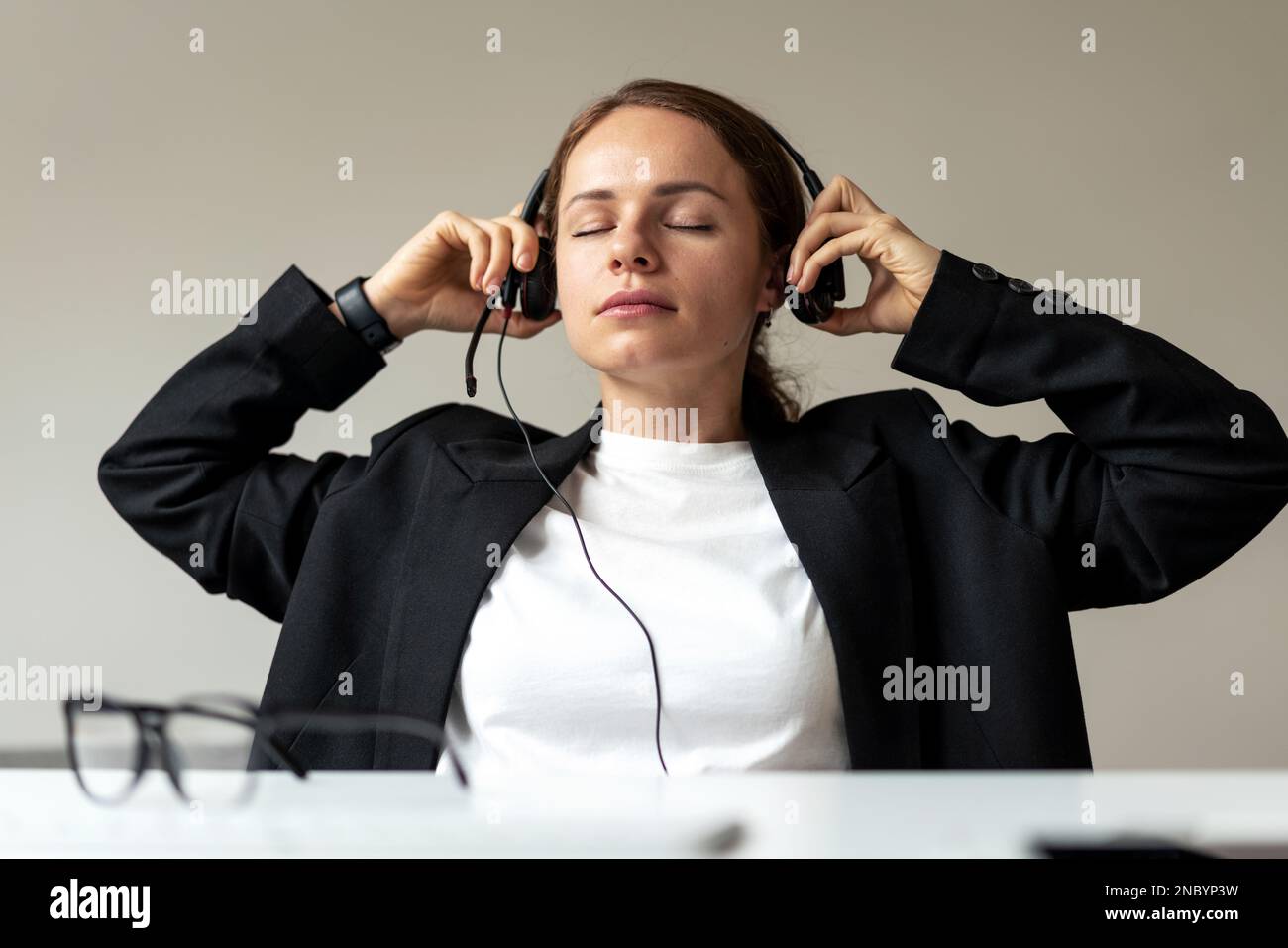 Una persona di lavoro stanca dopo una riunione online aziendale che ha rimosso la cuffia dalla testa. Foto Stock