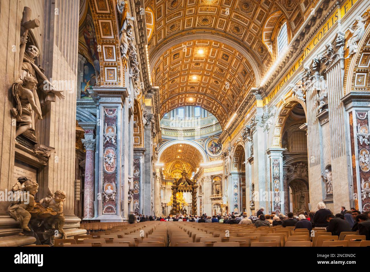 La gente partecipa a una messa nella Basilica di San Pietro in Vaticano Foto Stock