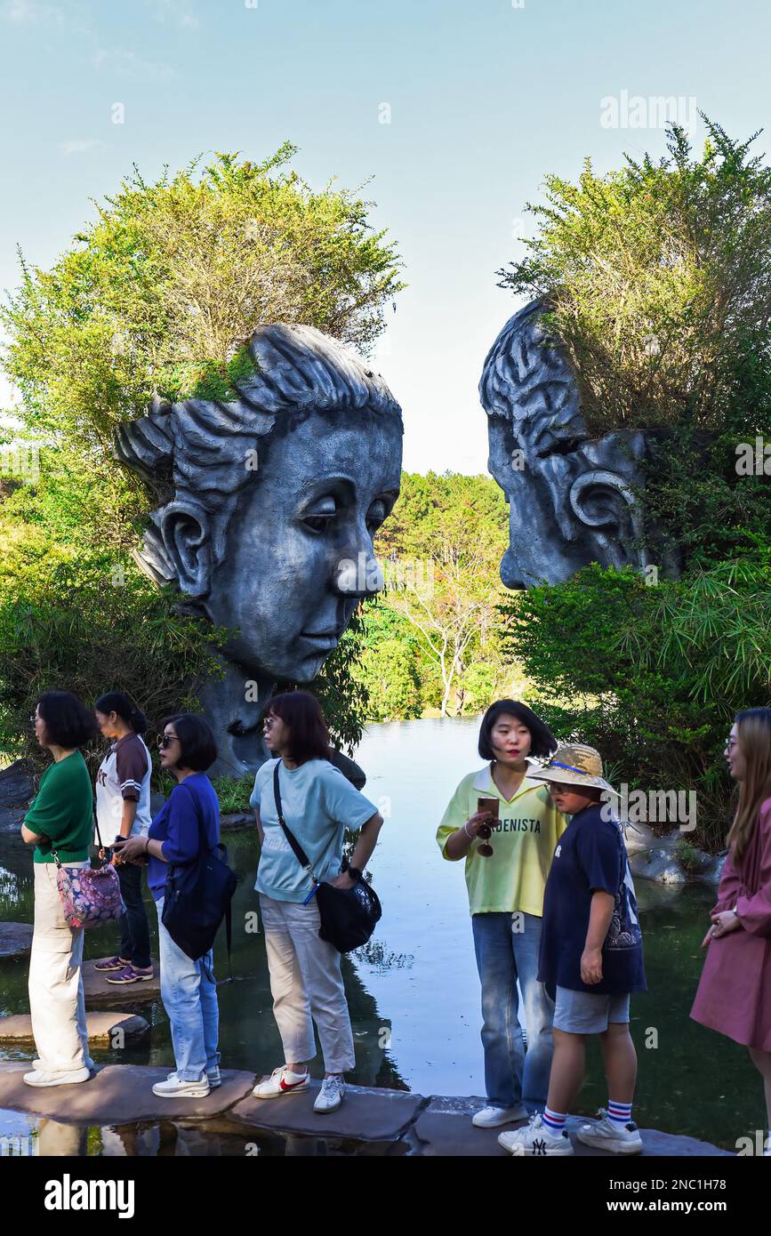 Da Lat, Vietnam - 9 febbraio 2023: Una linea di turisti cinesi che desiderano essere fotografati con una scultura di argilla in un villaggio di argilla Foto Stock